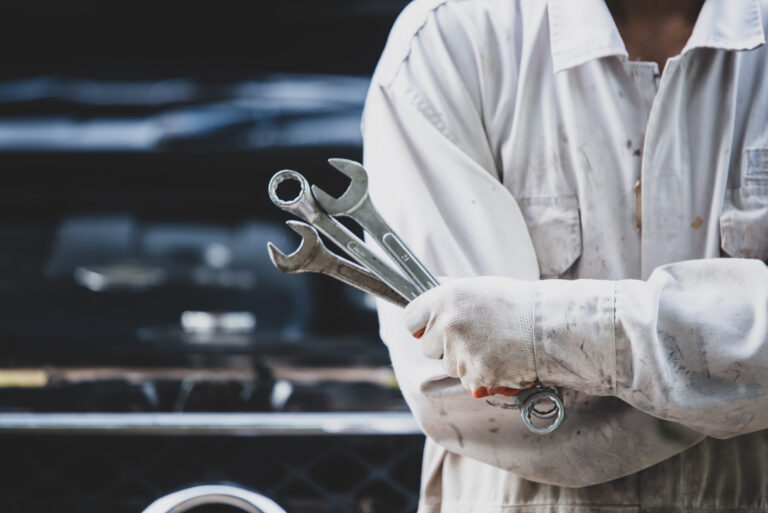 car repairman wearing white uniform standing holding wrench that is essential tool mechanic